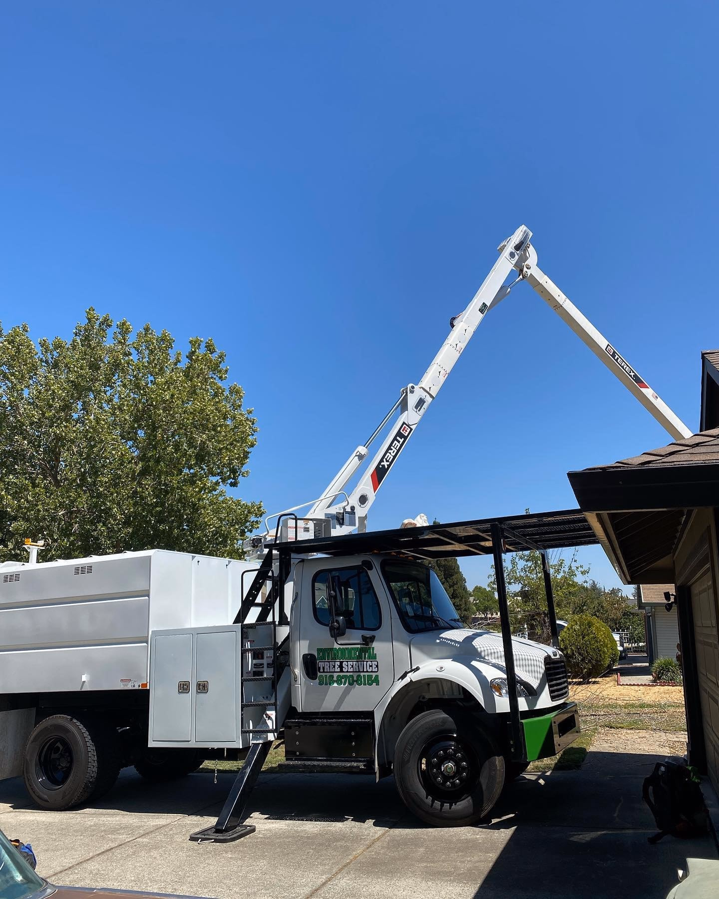 Environmental Tree Service: bucket truck with its boom raised at a job