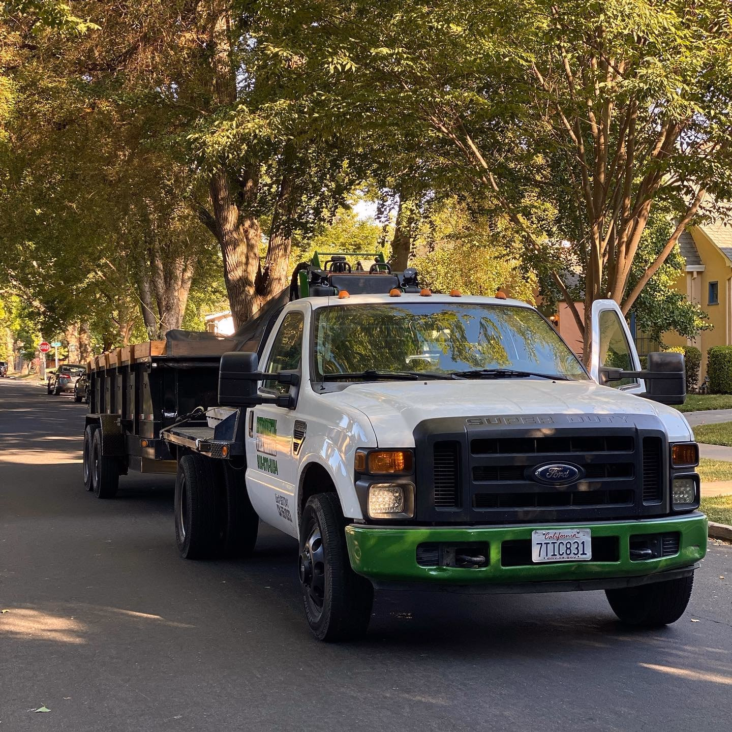 Environmental Tree Service: truck and trailer on a tree-lined street